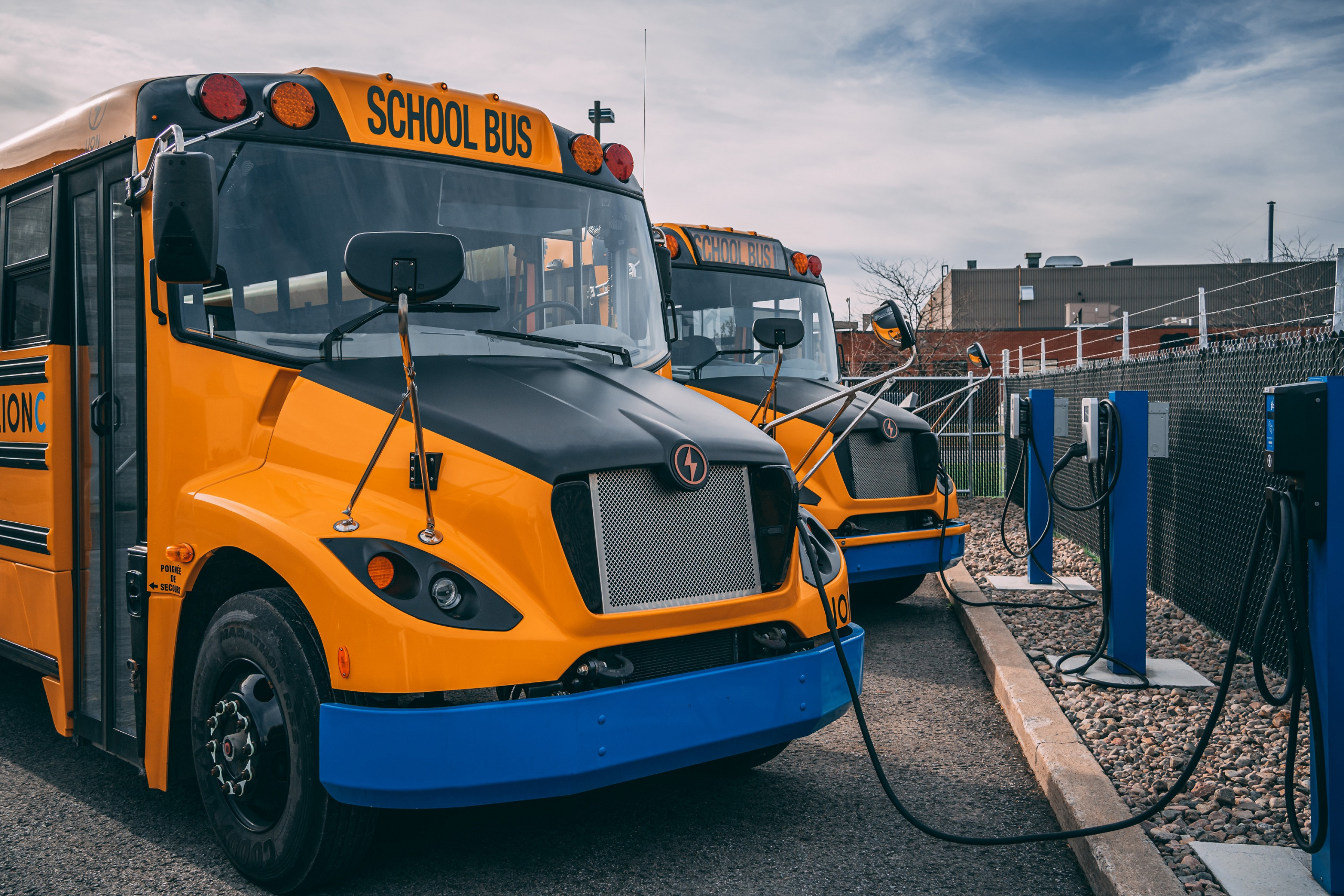An electric school bus with a plugged-in charging cable